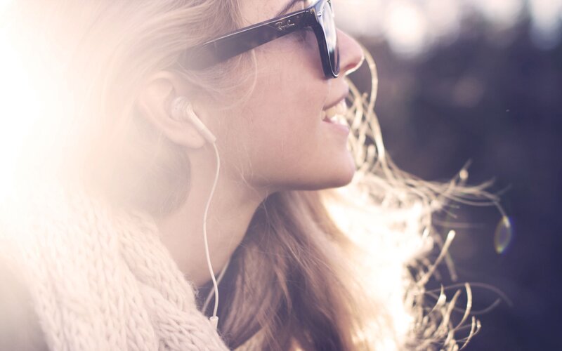 woman with sunglasses and earbuds