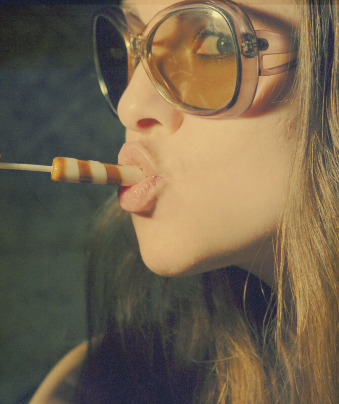 woman with sunglasses eating lollipop