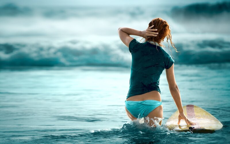 woman with surfboard in ocean