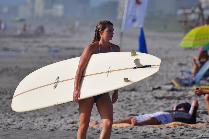 Woman with surfboard on beach