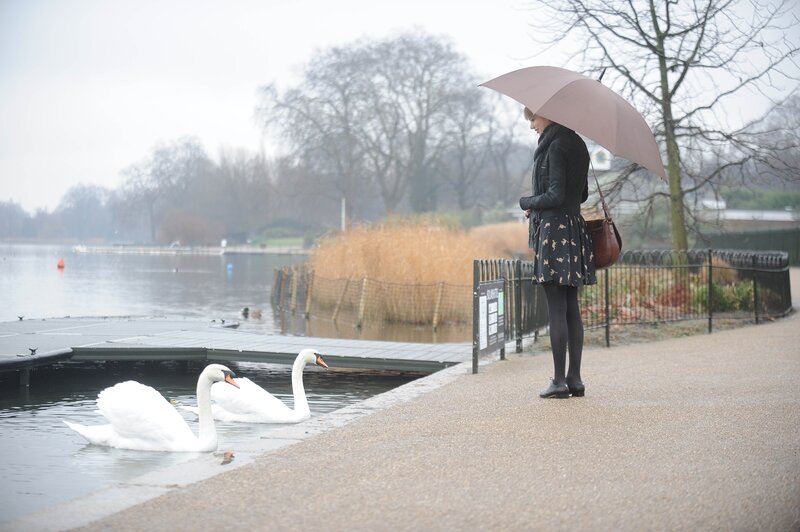 Woman with swans in the rain