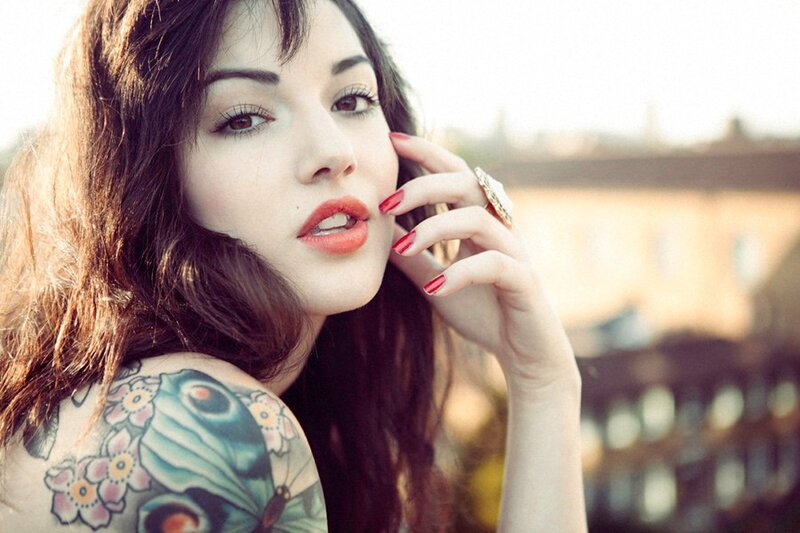 woman with tattoo and red nails