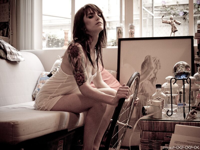 woman with tattoo holding bicycle wheel
