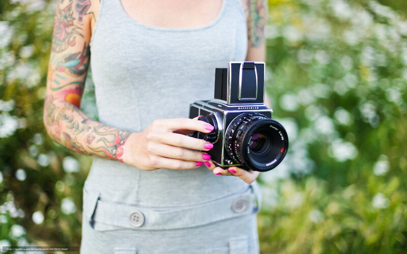 woman with tattoo holding camera