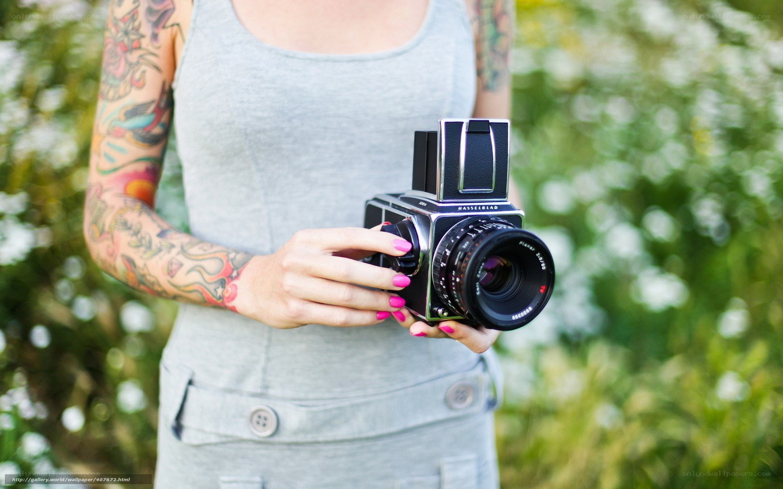 woman with tattoo holding camera
