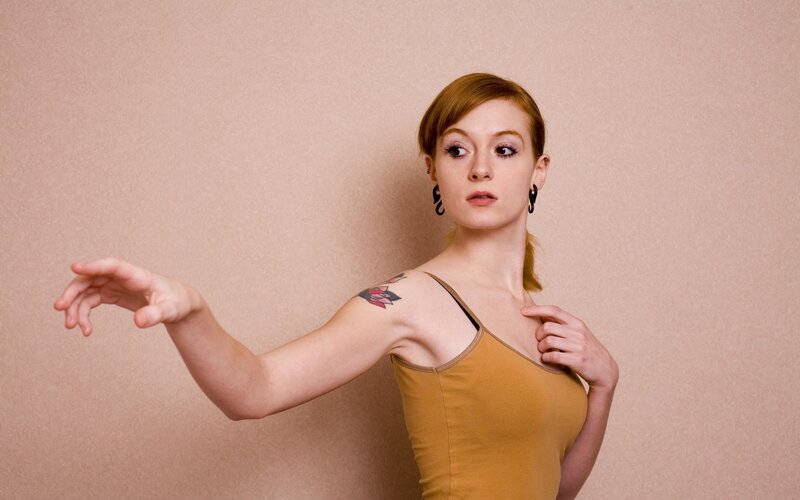 woman with tattoo in yellow top