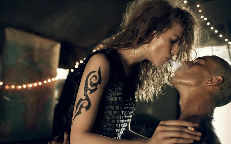 woman with tattoo kissing man