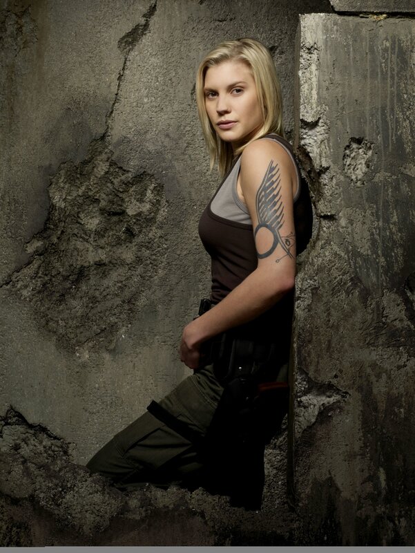 woman with tattoo leaning against wall