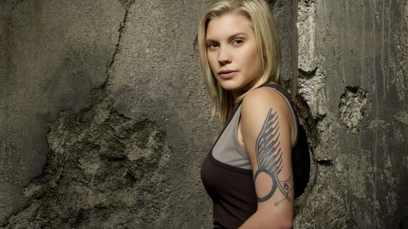 woman with tattoo leaning against wall