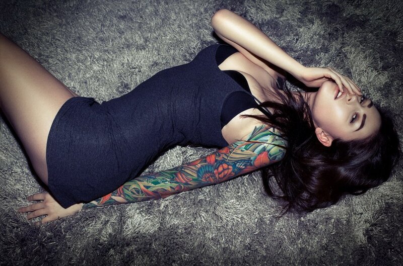 woman with tattoo lying on carpet