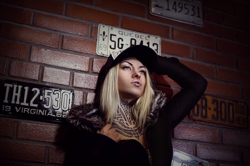woman with tattoos against brick wall