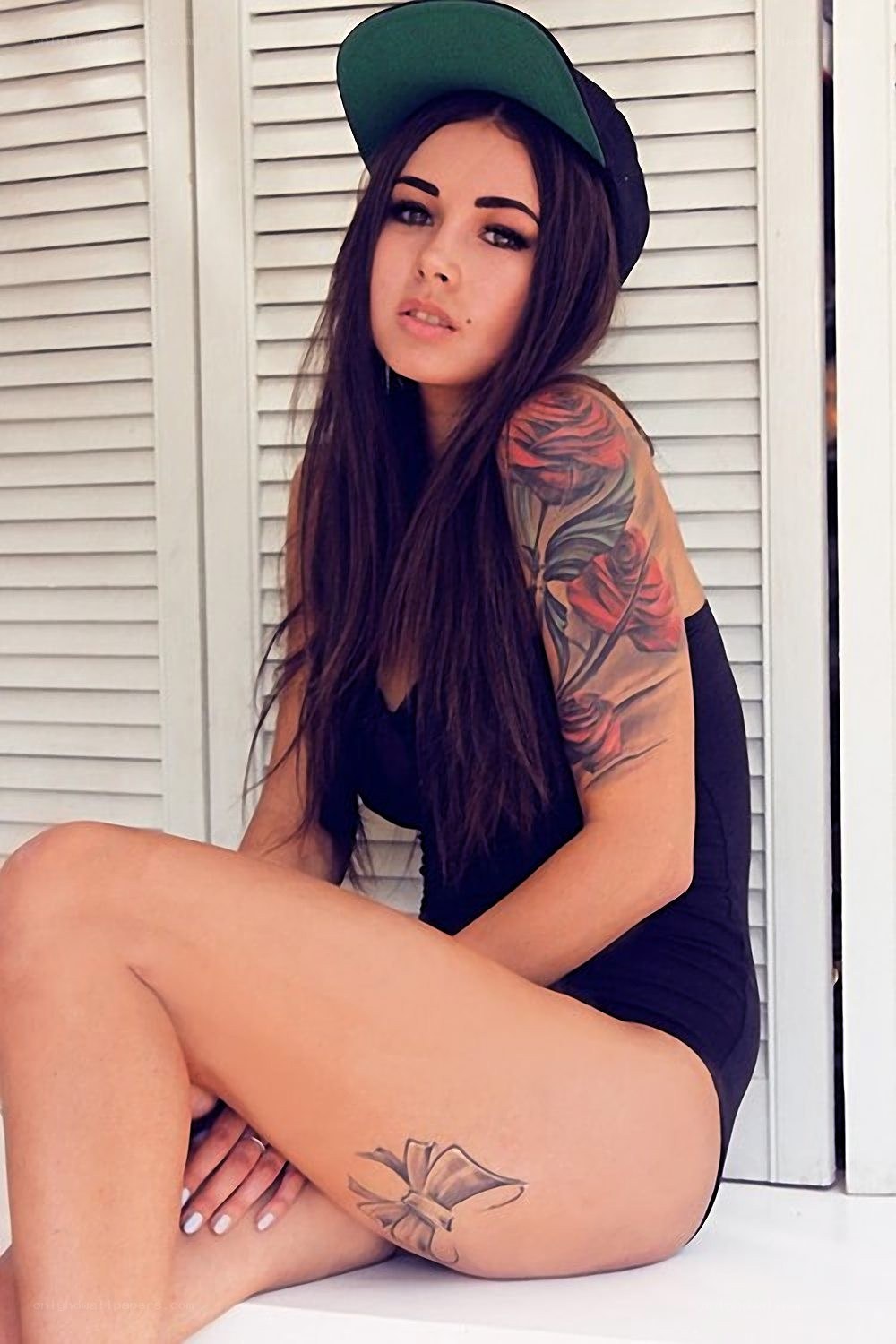 woman with tattoos and cap