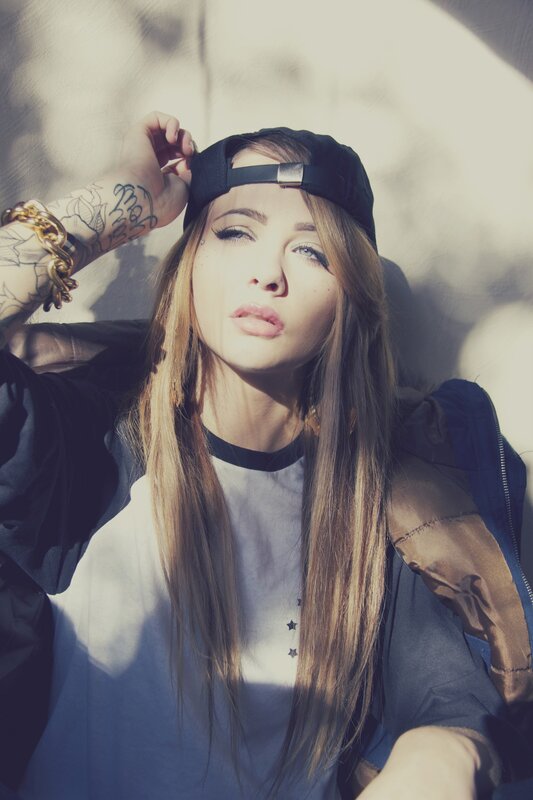 woman with tattoos and cap