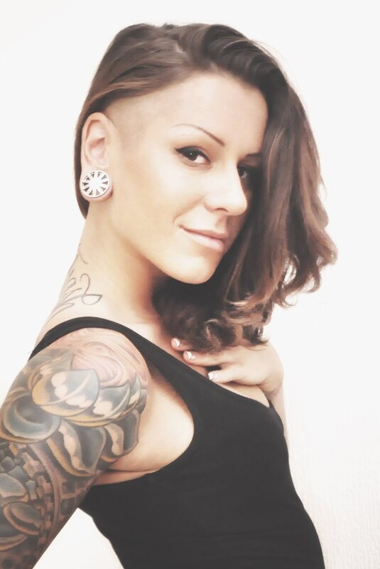 woman with tattoos and ear gauge