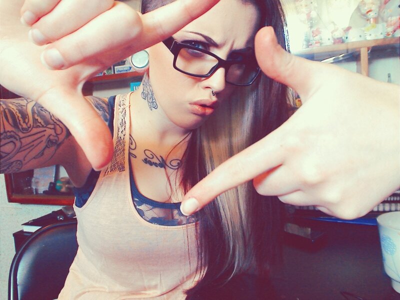 woman with tattoos and glasses