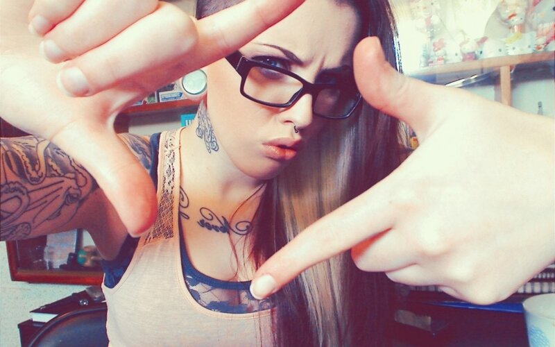 woman with tattoos and glasses
