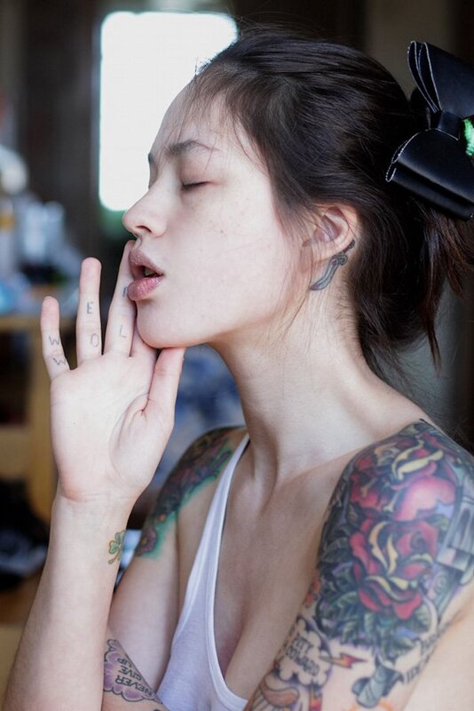 woman with tattoos and hand gesture