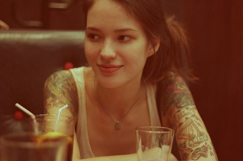 woman with tattoos at a table
