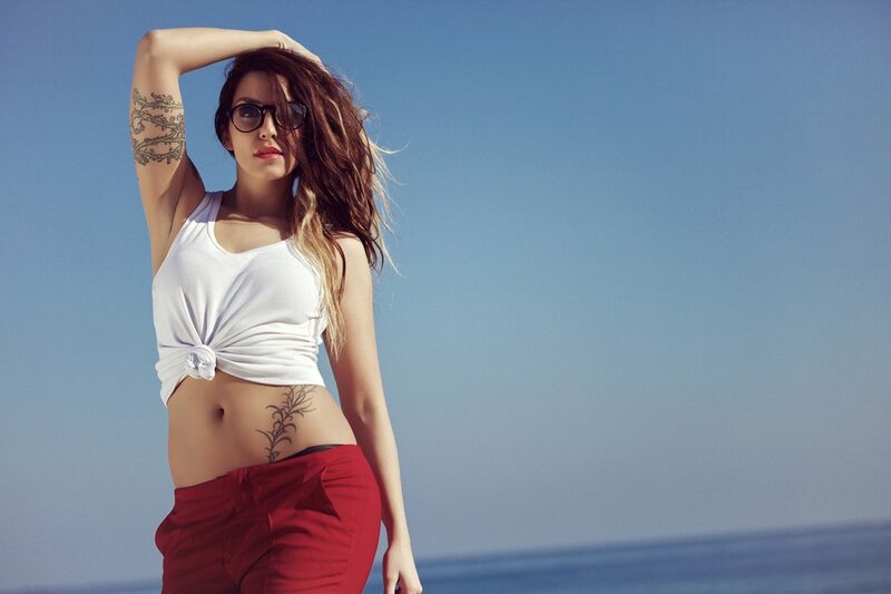 woman with tattoos at beach