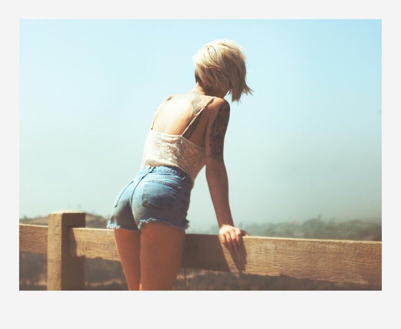 woman with tattoos at fence