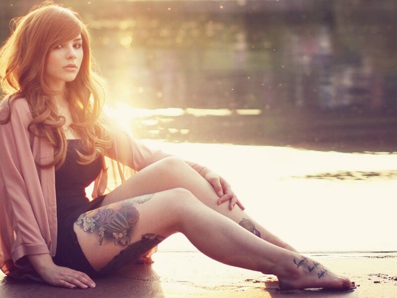 woman with tattoos at sunset