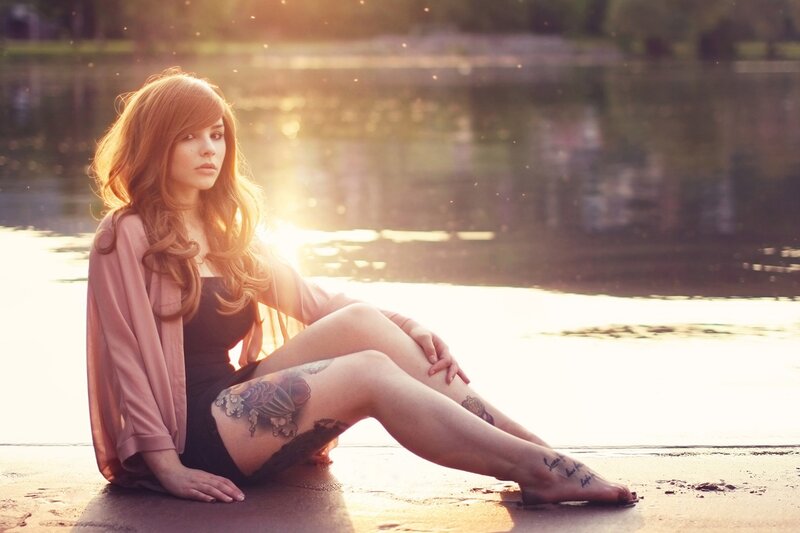 woman with tattoos by the water