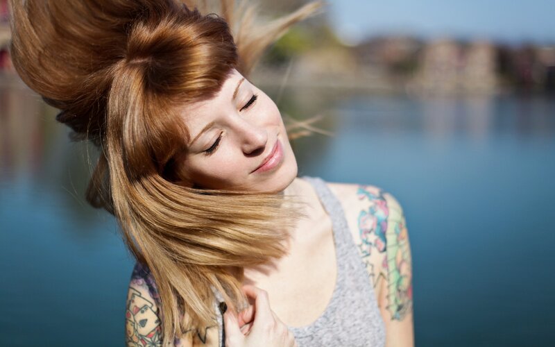 woman with tattoos by the water