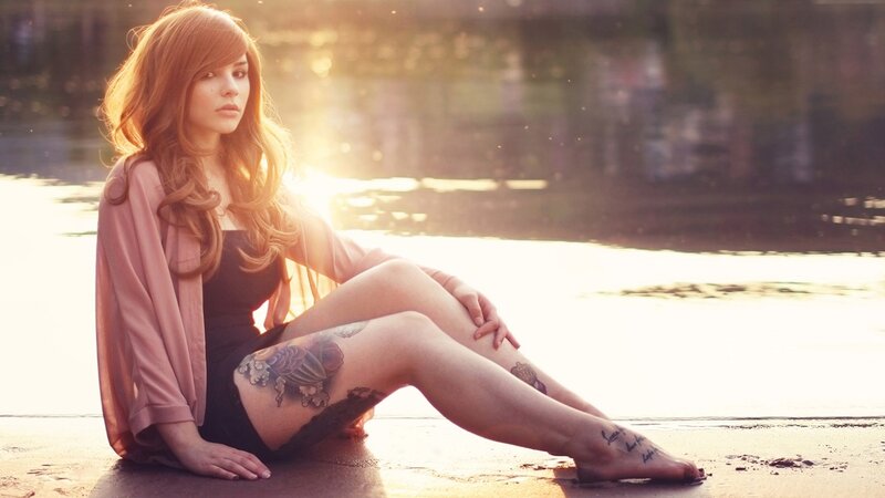 woman with tattoos by water