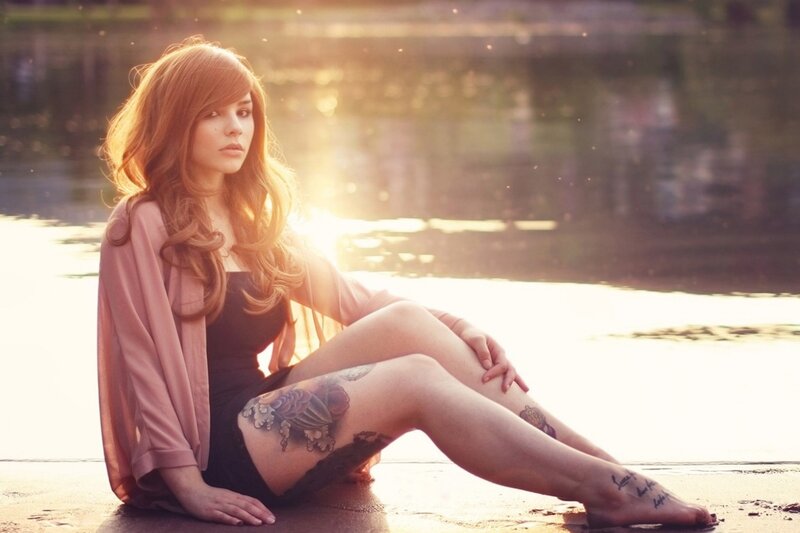 woman with tattoos by water