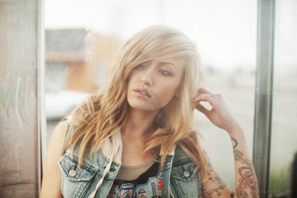 woman with tattoos by window