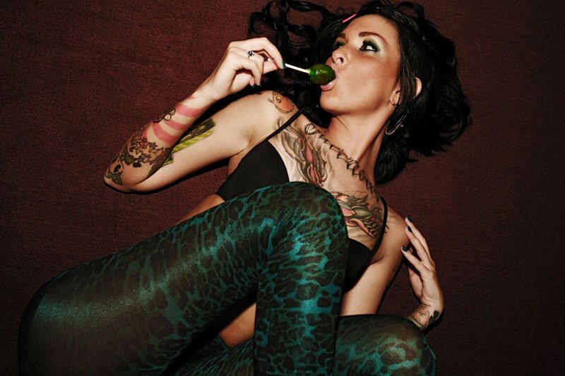 woman with tattoos eating lollipop