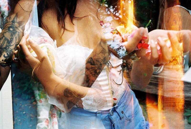 woman with tattoos holding flowers