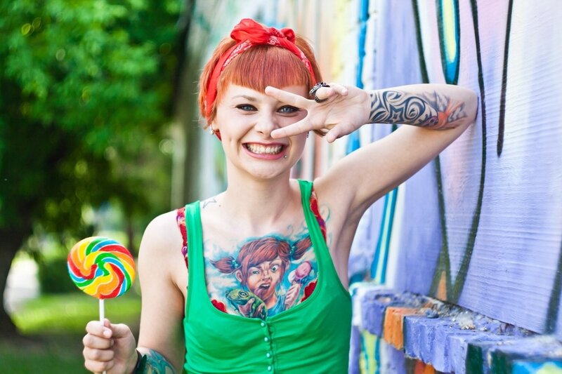 woman with tattoos holding lollipop