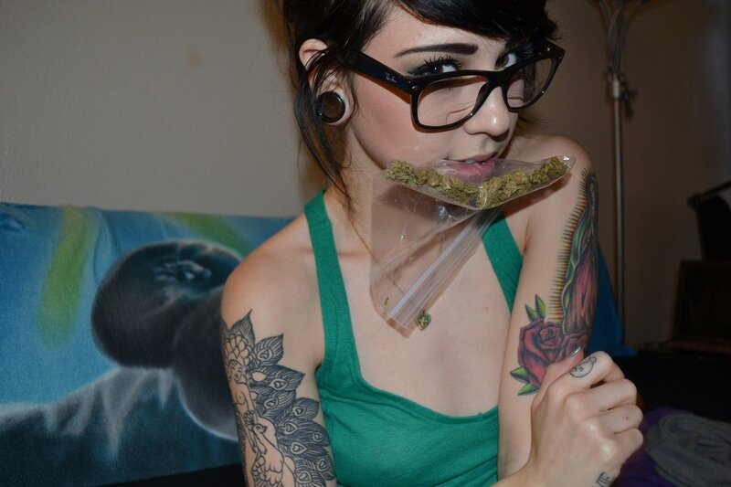 woman with tattoos holding marijuana