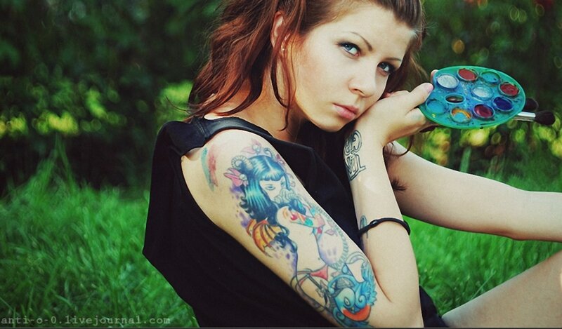woman with tattoos holding paint palette