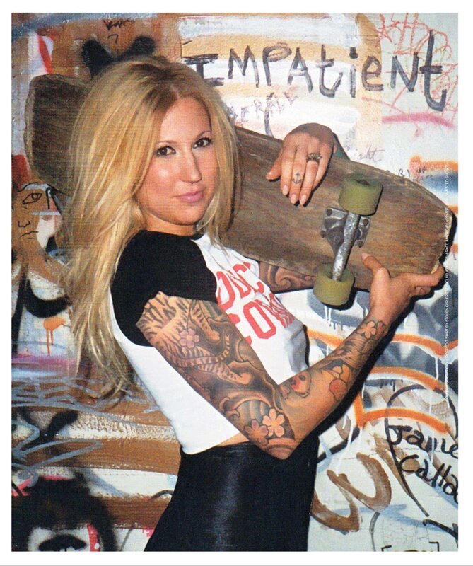woman with tattoos holding skateboard