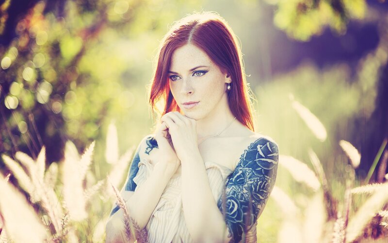 woman with tattoos in a field