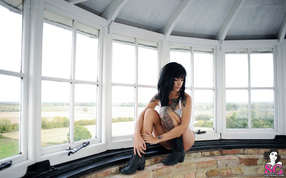 woman with tattoos in a window