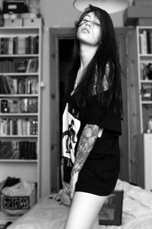 woman with tattoos in bedroom