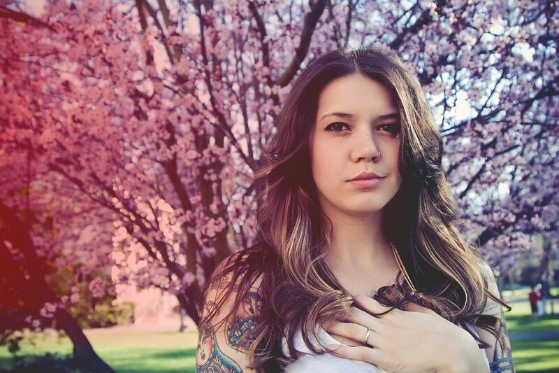 woman with tattoos in cherry blossom park