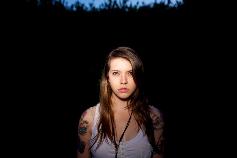 woman with tattoos in dark setting