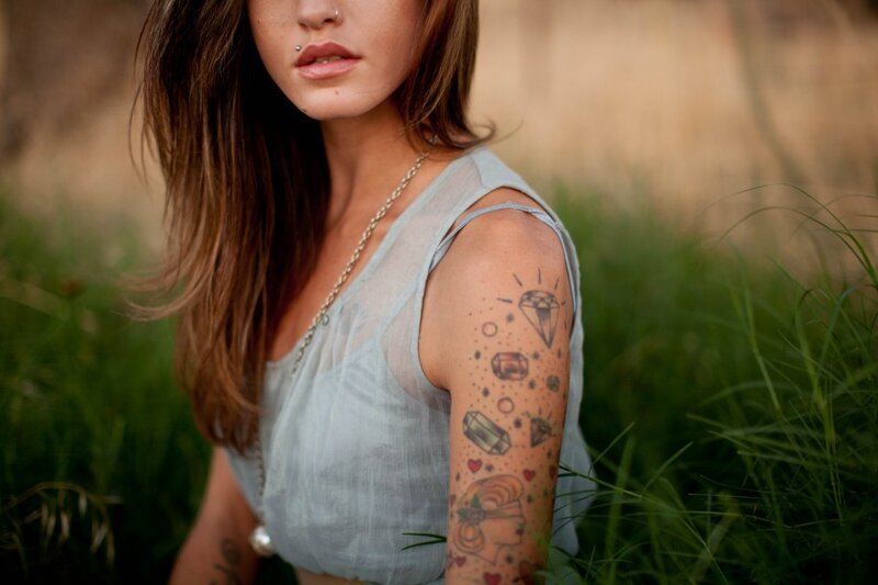 woman with tattoos in field