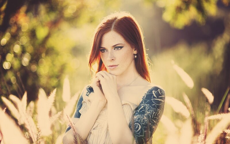 woman with tattoos in field