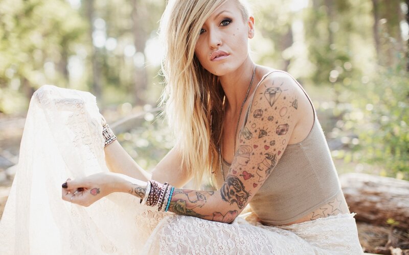 woman with tattoos in forest