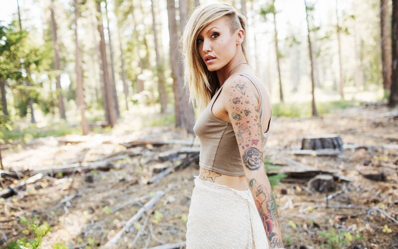 woman with tattoos in forest