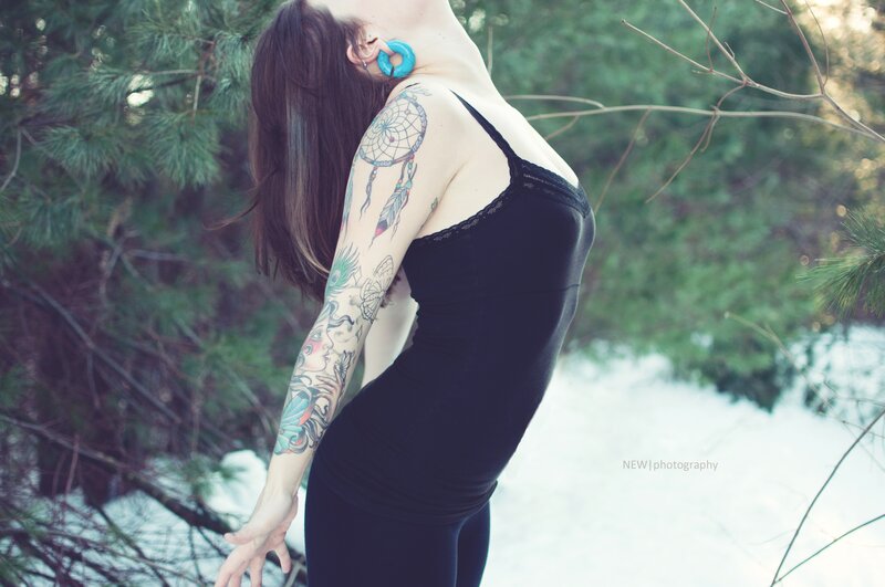 woman with tattoos in forest