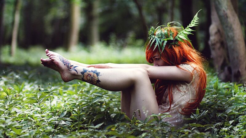 woman with tattoos in forest