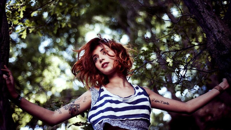 woman with tattoos in forest