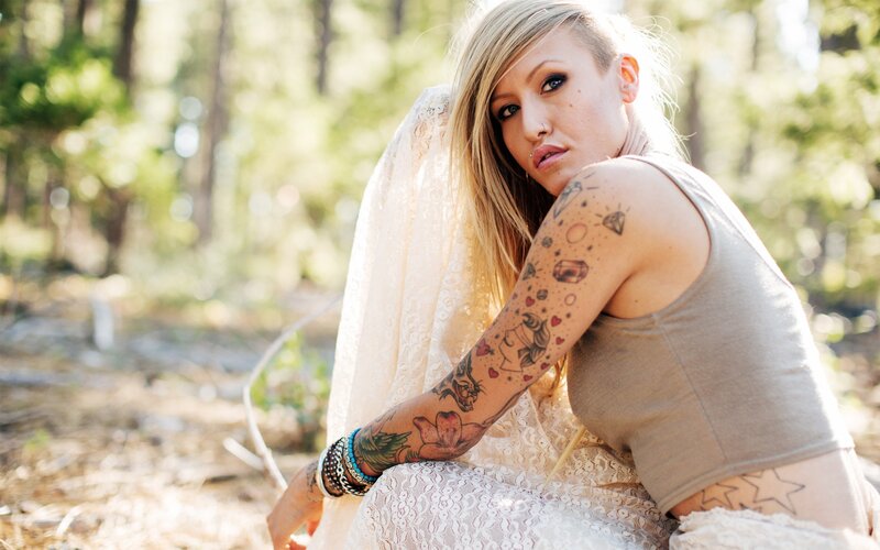 woman with tattoos in forest