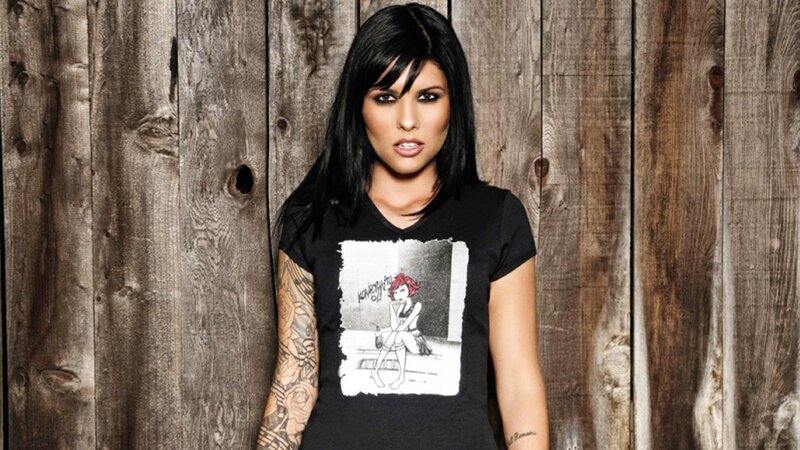 woman with tattoos in front of wood wall